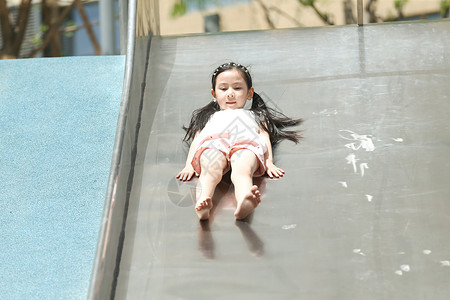 亚洲人3岁到4岁学龄前儿童小女孩在户外玩滑梯图片