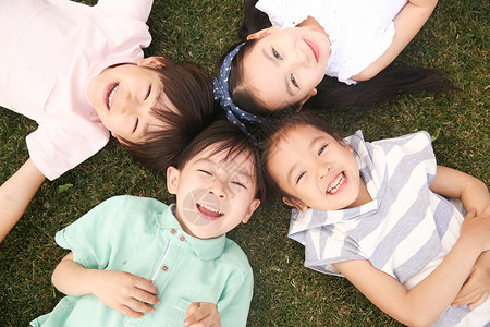 四个圆四个人5到6岁人快乐的孩子们在草地上玩耍背景