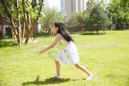 可爱的裙子高兴小女孩在户外玩耍图片