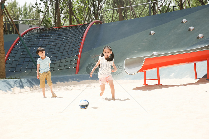 伙伴摄影人儿童在沙子里踢球图片