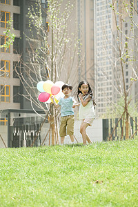 东方人友谊拿着快乐儿童在草地上玩耍图片