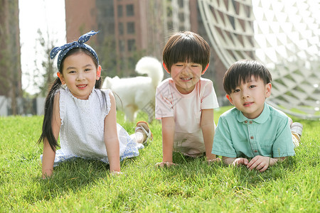 户外3岁到4岁全身像快乐的孩子趴在草地上图片