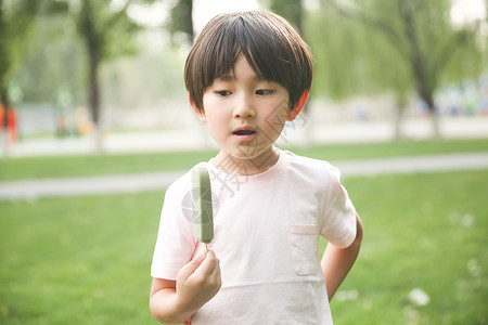 东方人可爱的冰淇淋小男孩吃冰棍图片