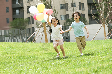 亚洲人人手牵手快乐儿童在草地上玩耍图片