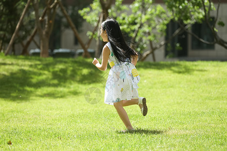 活动社区快乐休闲装东方人小女孩在户外玩耍背景