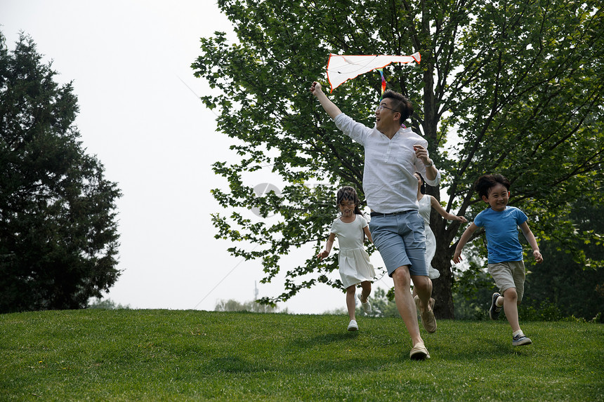 无忧无虑快乐家庭在草地上奔跑图片