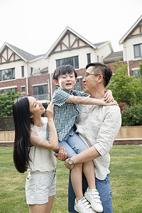 休闲装抱着青年男人幸福家庭在户外图片