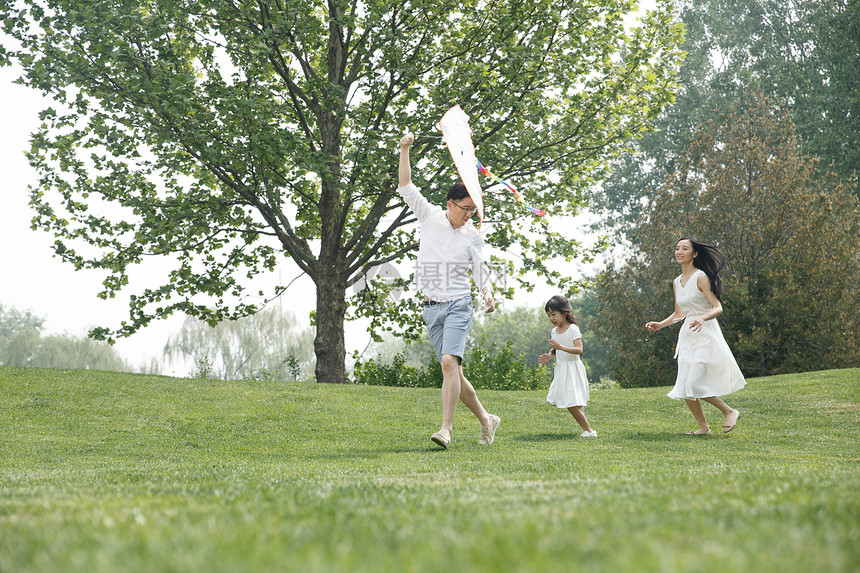 母亲三个人25岁到29岁一家三口在草地上放风筝图片