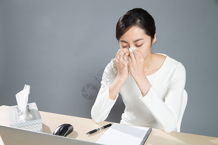 打喷嚏女仅一个女人打喷嚏电脑疲劳的女白领背景