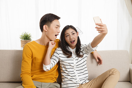 幸福面部表情住宅房间青年情侣用手机自拍图片