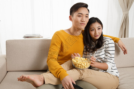 微笑爱乐趣青年情侣坐着沙发上看电视图片