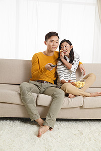 青年夫妇幸福异恋青年情侣坐着沙发上看电视图片