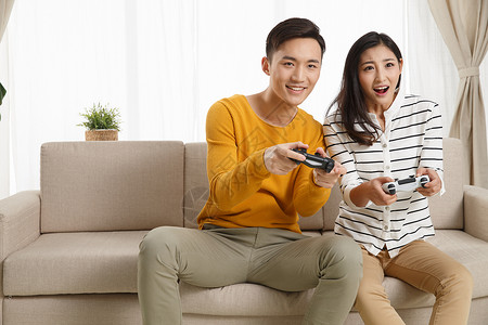 女朋友亚洲活力青年情侣坐着沙发上玩游戏图片
