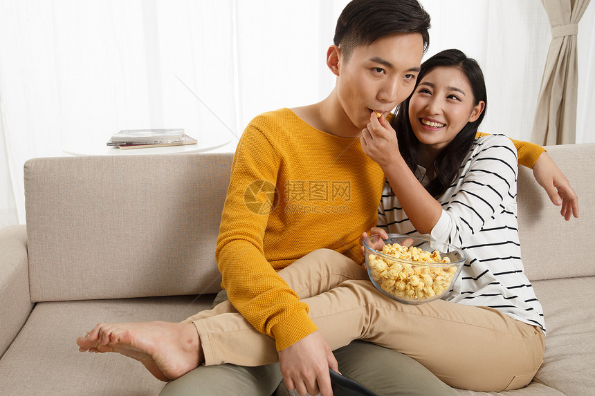 夫妇相伴人青年情侣坐着沙发上看电视图片