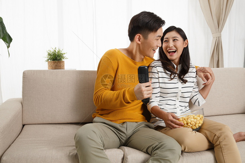 青年伴侣愉悦快乐青年情侣坐着沙发上看电视图片