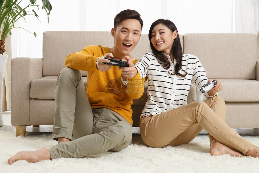 青年伴侣面部表情白昼青年情侣坐着沙发上玩游戏图片
