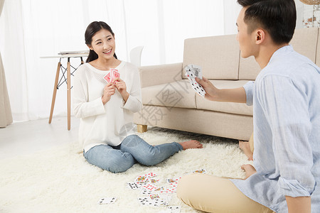 客厅浪漫相伴青年情侣玩扑克牌图片