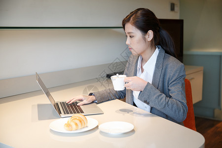 坐着现代青年女人吃早餐高清图片