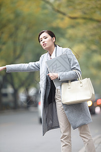 腕表女运输等车商务人士青年女人在路边等出租车背景