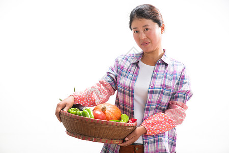 中年女人拿着一筐蔬菜高清图片