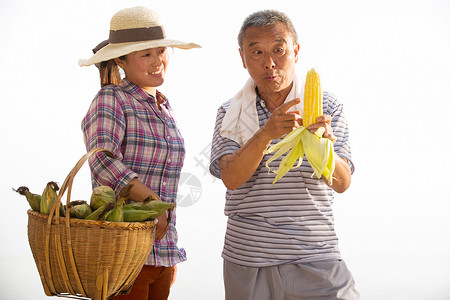 收获农作物愉悦的农民拿着玉米图片