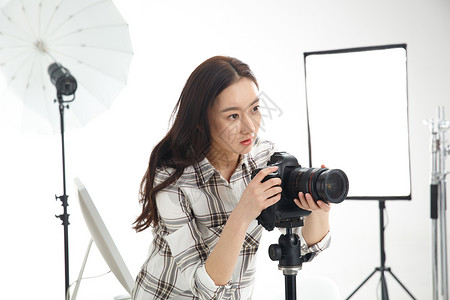 数码相机时尚照相机青年女摄影师拿着手机图片