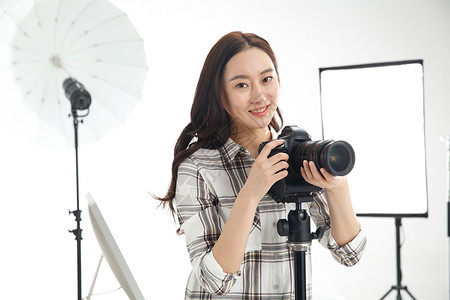 照明行业服务业职位仅一个青年女人设计行业青年女摄影师拿着手机背景