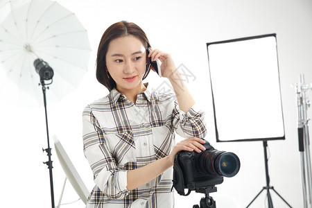 工业摄影师满意东方人微笑青年女摄影师拿着手机背景