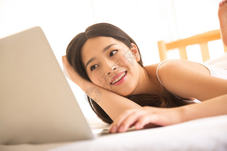 网上冲浪水平构图活力青年女人在卧室使用电脑图片