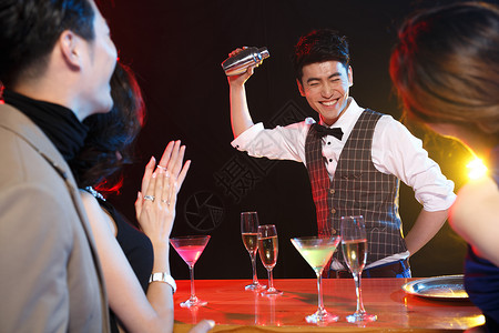 鸡尾酒快乐服务业职位光效果高脚杯青年男女在酒吧喝酒背景