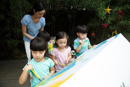 幼儿园户外游戏合作户外材料幼儿园的师生在做手工背景