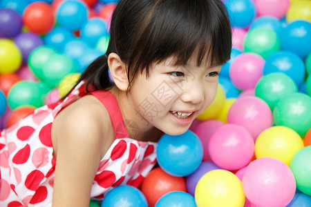 可爱的小女孩在游乐场玩耍海洋球图片