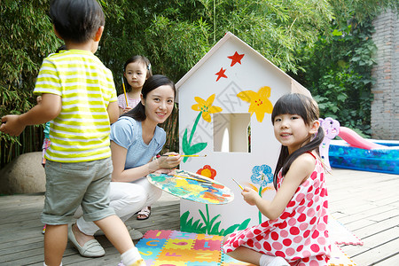 幼儿园户外游戏站着摄影私立学校幼儿园的师生在做手工背景