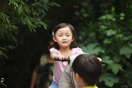休闲装童年冒险可爱的小女孩在骑摇摆木马高清图片