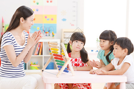 贡献亚洲人欢乐老师和儿童在幼儿园里关爱高清图片素材