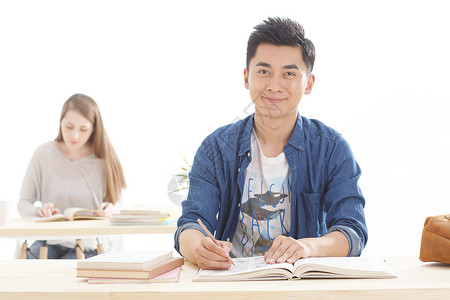 西方笔摄影白种人书桌年轻的大学生在学习背景