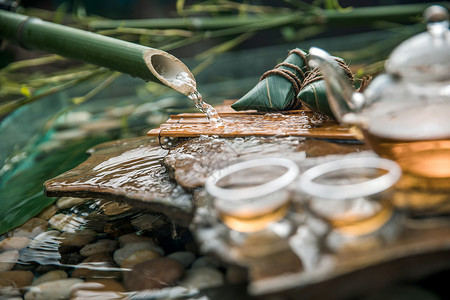 石头流流水下的粽子和茶背景