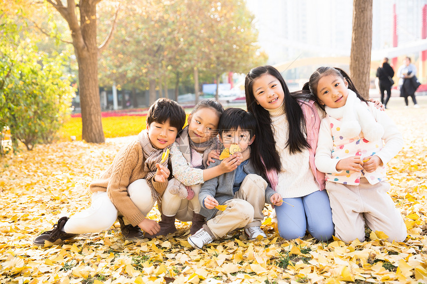 跪着树东方人可爱的男孩女孩在户外玩耍图片