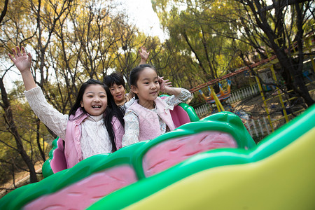 坐过山车孩子童年游乐园设施亚洲男孩女孩坐过山车背景