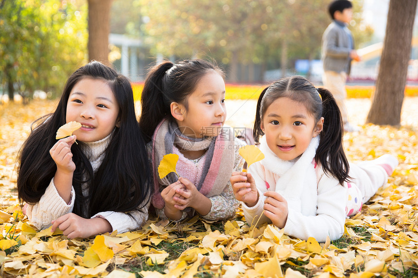 纯洁5到6岁趴着可爱的男孩女孩在户外玩耍图片