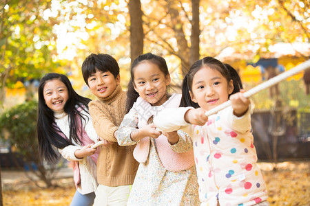 小孩拔河五个人度假成一排小学生在拔河比赛背景