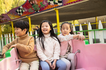 亚洲户外活动无忧无虑男孩女孩坐过山车图片