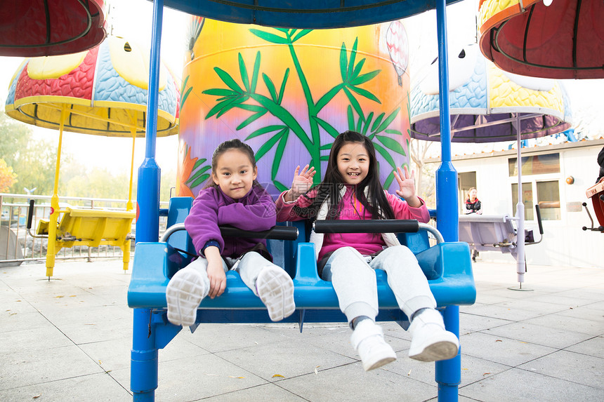 小学生愉快活力两个女孩在游乐场玩耍图片