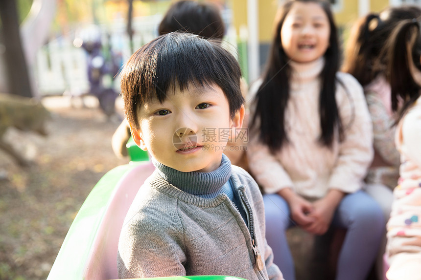 刺激小学生户外男孩女孩坐在游乐场玩耍图片