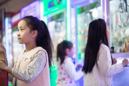 小学生玩游戏机公园北京8岁到9岁男孩女孩在游戏厅玩耍背景