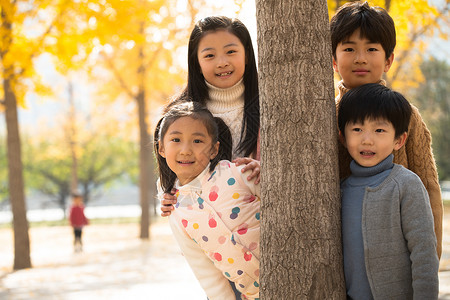 四个小孩休闲活动树干四个人欢乐的男孩女孩在户外玩耍背景