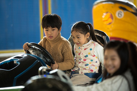 孩子在车里享乐亚洲兴奋小学生在游乐场玩耍背景