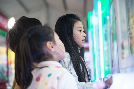 休闲游戏抓玩具游戏四个人男孩女孩在游戏厅玩耍图片