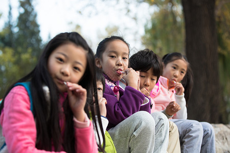 坐着伙伴北京可爱的男孩女孩在户外玩耍图片