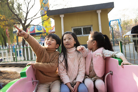 游戏安全伙伴户外活动公园男孩女孩坐过山车背景